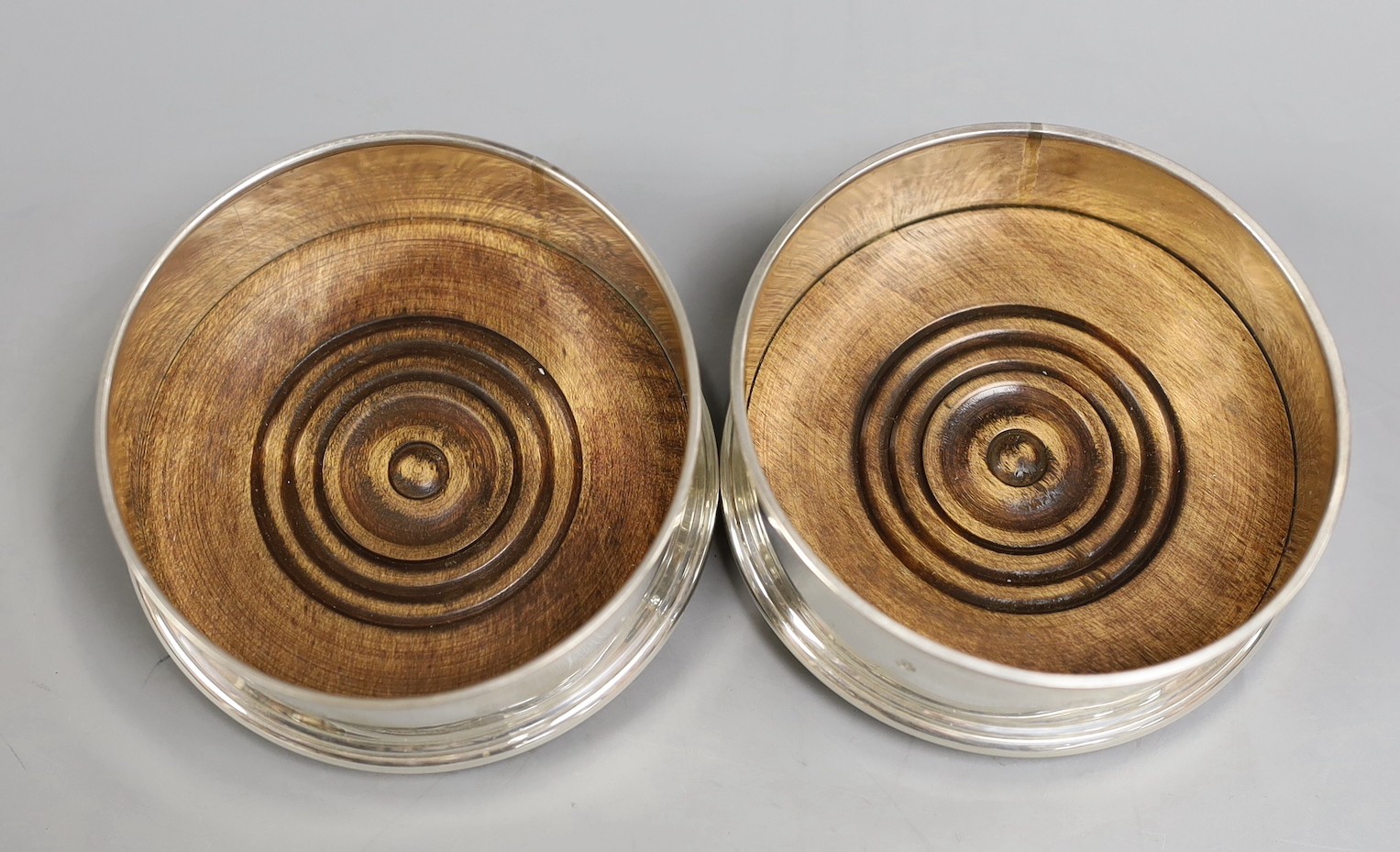 A pair of modern silver mounted wine coasters, M.C. Hersey & Son Ltd, London, 1993, diameter 9cm.